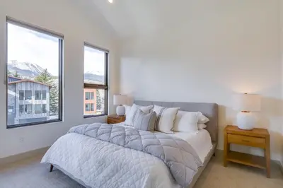 a bedroom with a large bed and two windows at Ski, Hike and Relax Fireside Silverthorne Getaway! in Silverthorne