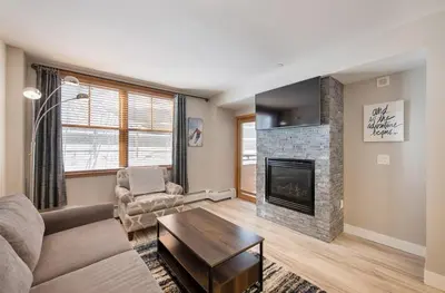 a living room with a couch and a fireplace at Premium Unit 1307 - 1 Bedroom - Zephyr Mountain condo in Winter Park