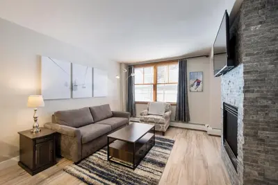 a living room with a couch and a fireplace at Premium Unit 1307 - 1 Bedroom - Zephyr Mountain condo in Winter Park