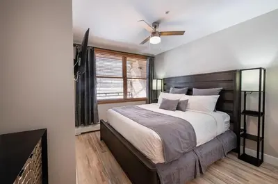 a bedroom with a large bed and a ceiling fan at Premium Unit 1307 - 1 Bedroom - Zephyr Mountain condo in Winter Park