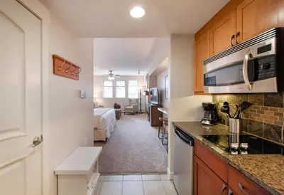 a kitchen with a counter top and a room with a bed at Premium Unit 4643- Fraser Crossing Founders Pointe condo in Winter Park