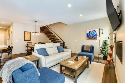 a living room with a white couch and blue chairs at Ski-InandSki-Out Granby Getaway with Fire Pit! in Granby