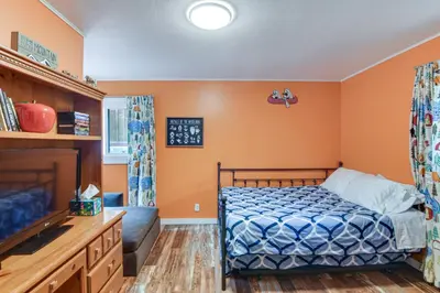a bedroom with a bed and a flat screen tv at Charming Idaho Springs Retreat on Chicago Creek! in Idaho Springs