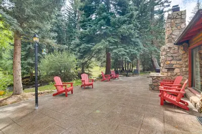 a group of red chairs sitting on a patio at Charming Idaho Springs Retreat on Chicago Creek! in Idaho Springs