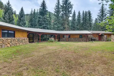 a stone house with a stone wall at Charming Idaho Springs Retreat on Chicago Creek! in Idaho Springs