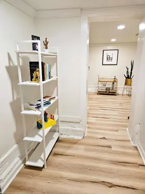 a hallway with white shelves and a hardwood floor at 2-Bedroom in the Heart of Denver in Denver
