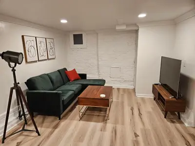 a living room with a green couch and a television at 2-Bedroom in the Heart of Denver in Denver