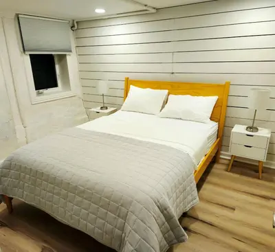 a bedroom with a bed with white sheets and a window at 2-Bedroom in the Heart of Denver in Denver