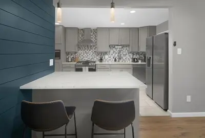 a kitchen with a white counter and two chairs at Spacious home near Anschutz/DIA in Aurora