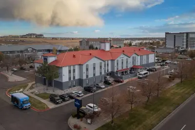 an aerial view of a building with a parking lot at AmericInn by Wyndham Denver Airport in Denver
