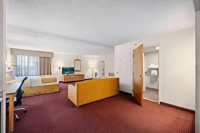 a hotel room with a bed and a desk at AmericInn by Wyndham Denver Airport in Denver