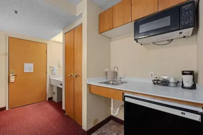 a small kitchen with a sink and a microwave at AmericInn by Wyndham Denver Airport in Denver