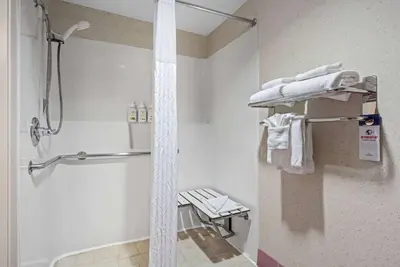 a bathroom with a shower and a towel rack at AmericInn by Wyndham Denver Airport in Denver