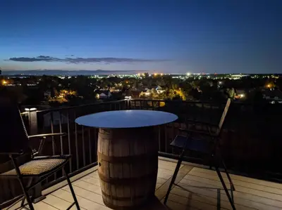 a table and chairs on a balcony at night at 2B2B pet-friendly with views near dog park in Westminster
