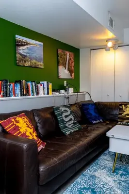 a brown leather couch in a living room with a book shelf at 2B2B pet-friendly with views near dog park in Westminster