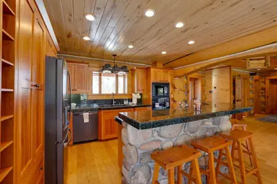 a kitchen with a large stone island in a cabin at Fraser Chalet with Hot Tub and Mountain Views in Fraser