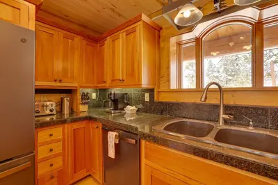 a kitchen with wooden cabinets and a sink at Fraser Chalet with Hot Tub and Mountain Views in Fraser