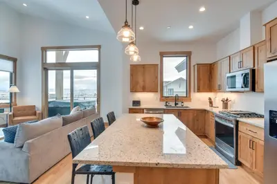 a kitchen and living room with a table and a couch at Winter Park Retreat Balcony, Hot Tub and Fireplace! in Fraser