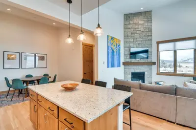 a kitchen and living room with a couch and a table at Winter Park Retreat Balcony, Hot Tub and Fireplace! in Fraser