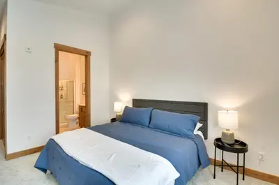 a bedroom with a blue and white bed and a bathroom at Winter Park Retreat Balcony, Hot Tub and Fireplace! in Fraser