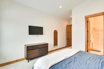 a bedroom with a bed and a tv on a wall at Winter Park Retreat Balcony, Hot Tub and Fireplace! in Fraser