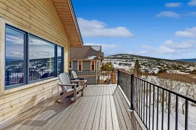 a wooden deck with a chair on the side of a house at Lone Eagle in Granby