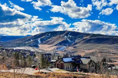 a house on a hill in front of a mountain at Lone Eagle in Granby