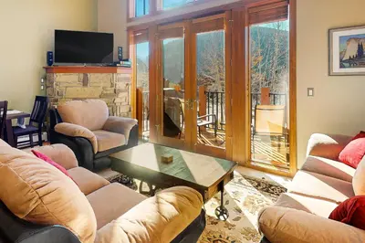 a living room with couches and a table and a balcony at Antlers Gulch Townhomes #71 in Keystone