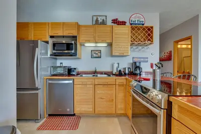 a kitchen with wooden cabinets and stainless steel appliances at Heated Pool Access and Near Skiing Colorado Retreat in Silverthorne