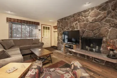 a living room with a large stone fireplace at Hi Country Haus - 10-18,,, condo in Winter Park