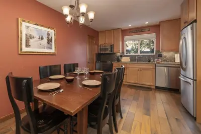 a kitchen with a wooden table with chairs and a refrigerator at Hi Country Haus - 10-18,,, condo in Winter Park