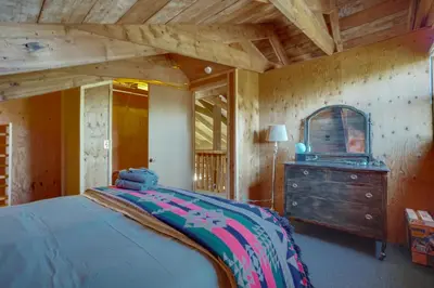 a bedroom with a bed and a dresser in a room at Red Feather Lakes Cabin with Deck and Views! in Red Feather Lakes