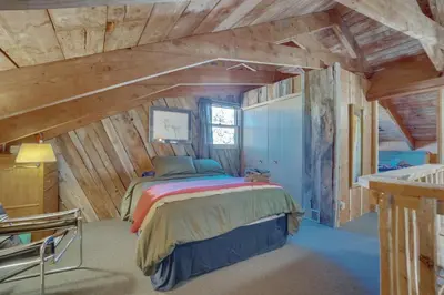 a bedroom with a bed in a room with wooden ceilings at Red Feather Lakes Cabin with Deck and Views! in Red Feather Lakes