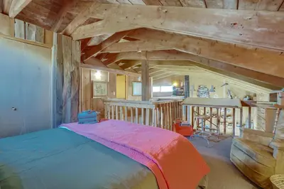 a bedroom with a bed in a room with wooden ceilings at Red Feather Lakes Cabin with Deck and Views! in Red Feather Lakes