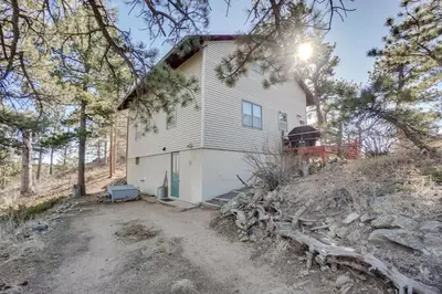 a house on top of a hill with trees at Red Feather Lakes Cabin with Deck and Views! in Red Feather Lakes