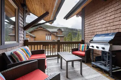 a screened in porch with a grill and chairs at 45 Thackwell Lane townhouse in Keystone