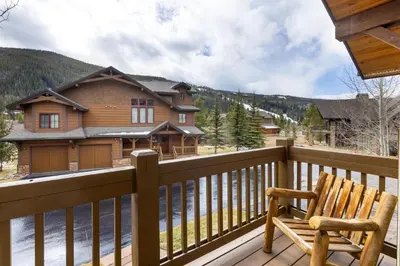 a wooden chair sitting on a balcony with a house at 45 Thackwell Lane townhouse in Keystone