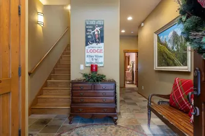a hallway with a stairway with a wooden dresser and a stairwayoker at 45 Thackwell Lane townhouse in Keystone