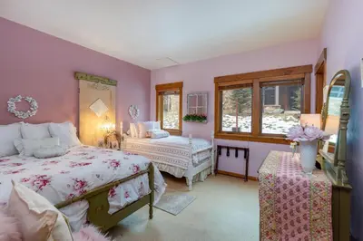 a pink bedroom with two beds and a window at 45 Thackwell Lane townhouse in Keystone