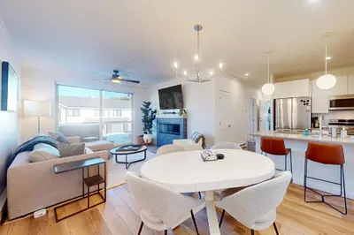 a living room and kitchen with a white table and chairs at Mellow on Meadow Mile in Fraser