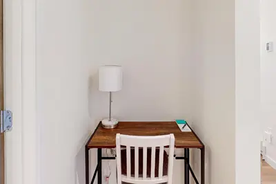 a table with a lamp and a white chair at Mellow on Meadow Mile in Fraser