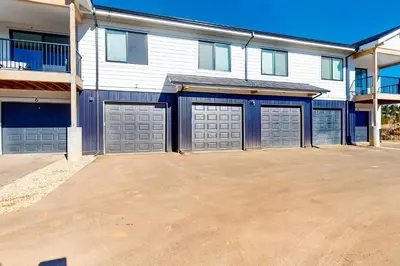 a large house with three garage doors in a driveway at Mellow on Meadow Mile in Fraser