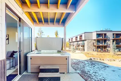 a hot tub on a patio with a view of a building at Mellow on Meadow Mile in Fraser