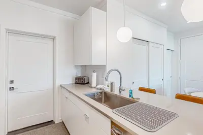 a kitchen with white cabinets and a sink at Mellow on Meadow Mile 2A in Fraser