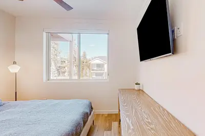 a bedroom with a bed and a large window at Mellow on Meadow Mile 2A in Fraser