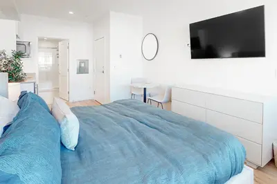 a bedroom with a large bed with a tv on the wall at Mellow on Meadow Mile 2B in Fraser