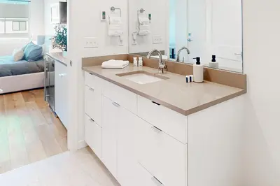 a white kitchen with a sink and a mirror at Mellow on Meadow Mile 2B in Fraser