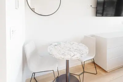 a round table with two white chairs and a mirror at Mellow on Meadow Mile 2B in Fraser