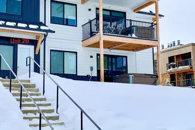 a building with a balcony and stairs in the snow at Mellow on Meadow Mile 2B in Fraser