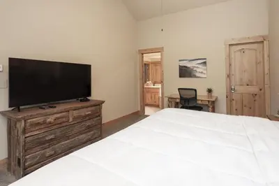a bedroom with a large white bed and a flat screen tv at Antler Way at Lakota,,,, townhouse in Winter Park